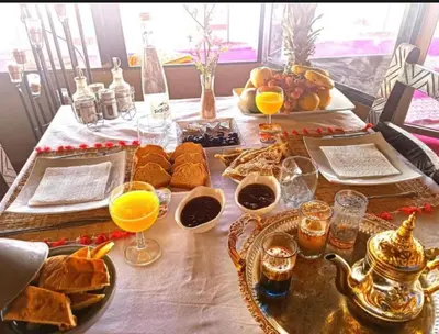 a table with bread and orange juice and drinks at Fantastic desert camp in Oulad Akkou