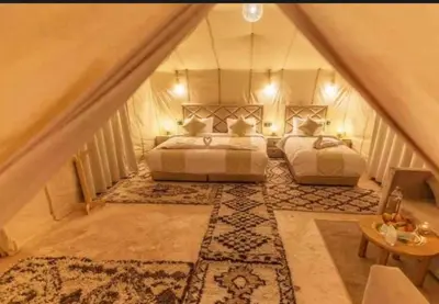 a attic bedroom with two beds and a rug at Fantastic desert camp in Oulad Akkou