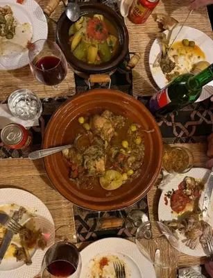a table with a bowl of food and plates of food at Fantastic desert camp in Oulad Akkou