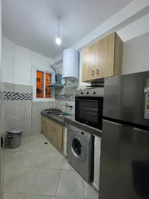 a kitchen with a stove and a washer and dryer at Appartement in Fès