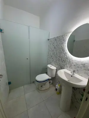 a bathroom with a toilet and a sink and a mirror at Appartement in Fès