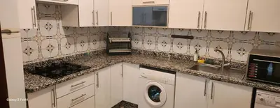 a kitchen with a washing machine and a sink at Dar imzouren al quods in Oulad Akkou