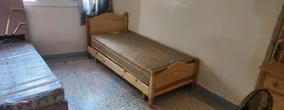 a small bed in a corner of a room at Dar imzouren al quods in Oulad Akkou