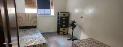 a room with a room with a table and a fan at Dar imzouren al quods in Oulad Akkou