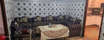a couch with a table in a room at Dar imzouren al quods in Oulad Akkou