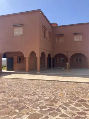a large brick building with arches and a patio at Villa Syam in Tiflet