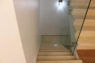 a stairwell with a glass railing and wooden stairs at Villa moulay abdella in Marrakech