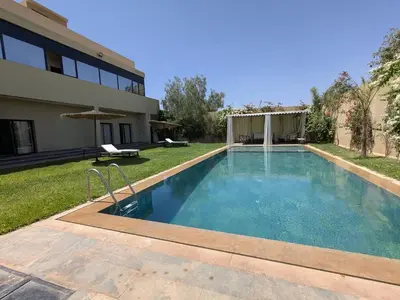 a swimming pool in the backyard of a house at Villa moulay abdella in Marrakech