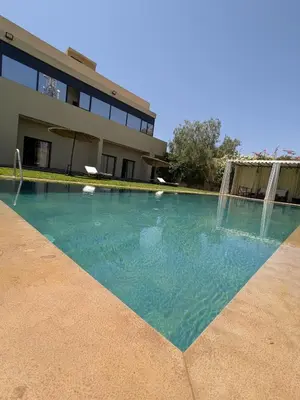 a swimming pool in front of a house at Villa moulay abdella in Marrakech