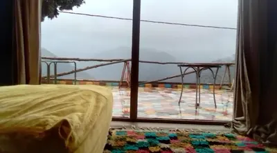 a bedroom with a large window with a view of a room at Refuge AIT M'HAMED