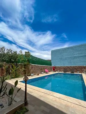 a swimming pool in front of a building at Blue Atlas Villa in Igrif Foudene