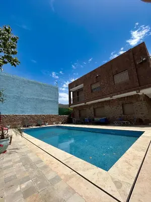 a swimming pool in front of a building at Blue Atlas Villa in Igrif Foudene