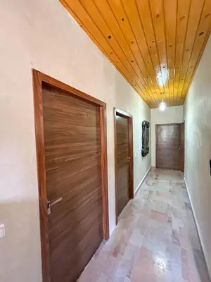 a hallway with two doors and a wooden ceiling at Blue Atlas Villa in Igrif Foudene