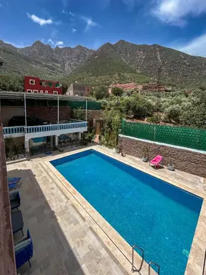 a swimming pool with mountains in the background at Blue Atlas Villa in Igrif Foudene
