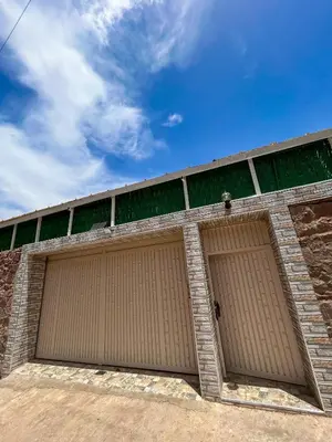 two brown garage doors on a brick building at Blue Atlas Villa in Igrif Foudene