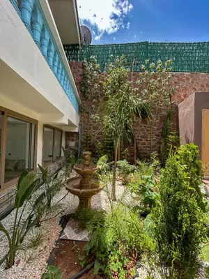 a garden with a bird bath in front of a building at Blue Atlas Villa in Igrif Foudene