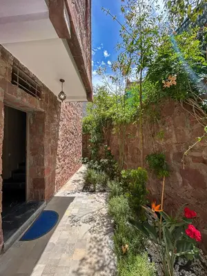 an external walkway to a brick building with flowers at Blue Atlas Villa in Igrif Foudene