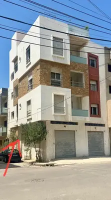 a building with two garage doors on a street at Tétouan Rooftop Stay in Oulad Akkou