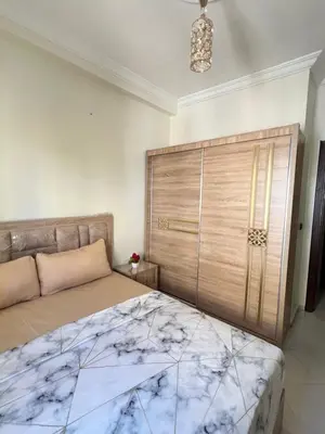 a bedroom with a bed and a large wooden headboard at Diyar tanger in Oulad Akkou