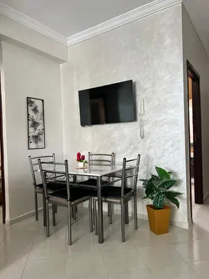 a dining room with a table and chairs and a tv at Diyar tanger in Oulad Akkou