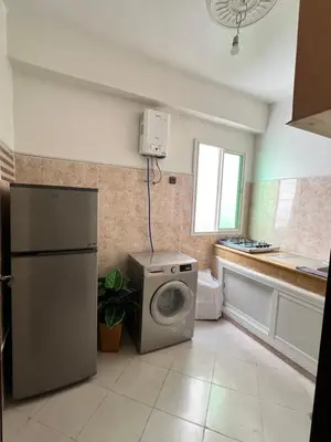 a kitchen with a refrigerator and a washing machine at Diyar tanger in Oulad Akkou