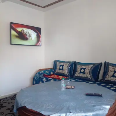 a room with a bed with a table in it at ديار البوغاز in Oulad Akkou
