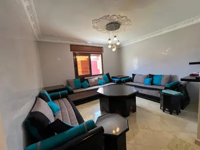 a living room with couches and a table at Oum kaltoum in Oulad Akkou