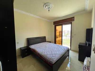a bedroom with a bed and a sliding glass door at Oum kaltoum in Oulad Akkou
