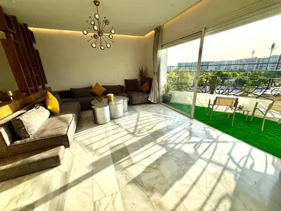 a living room with a couch and a large window at Appartement avec vue sur Parc champs de course et Wifi 200 Mo in Oulad Akkou