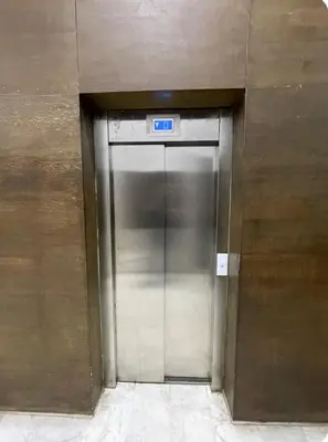 a elevator door in a building with a sign on it at Appartement avec vue sur Parc champs de course et Wifi 200 Mo in Oulad Akkou