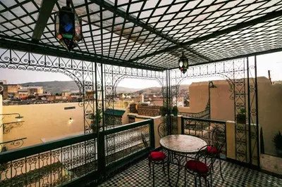 a balcony with a table and chairs on a balcony at Le panoramique de Fes in Fès