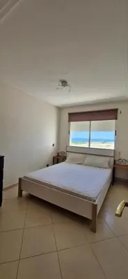 a bedroom with a large bed with a window at Apartamentos rent me in Oulad Akkou