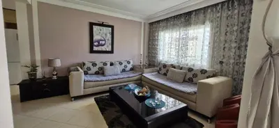 a living room with a couch and a table at Apartamentos rent me in Oulad Akkou