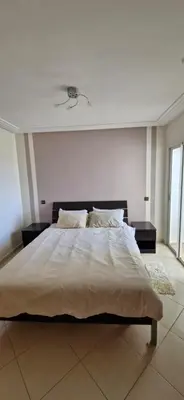 a bedroom with a large bed with two night stands at Apartamentos rent me in Oulad Akkou