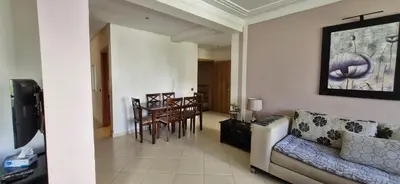 a living room with a couch and a dining room at Apartamentos rent me in Oulad Akkou