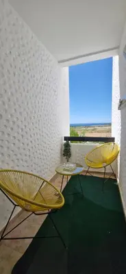 a room with two yellow chairs and a window at Apartamentos rent me in Oulad Akkou