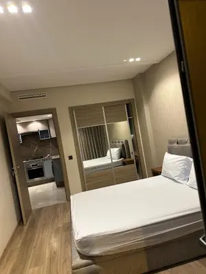a small room with a bed and a mirror at Studio haut standing in Oulad Akkou