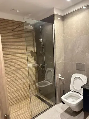 a bathroom with a toilet and a glass shower at Studio haut standing in Oulad Akkou