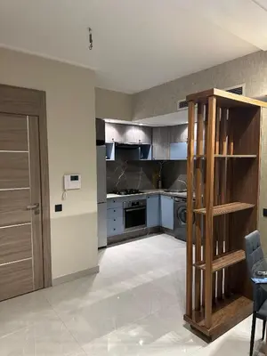 a large kitchen with a stove and a counter at Studio haut standing in Oulad Akkou