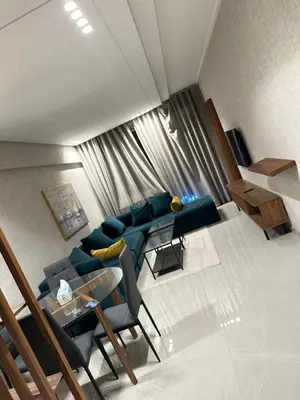 a living room with a blue couch and a table at Studio haut standing in Oulad Akkou