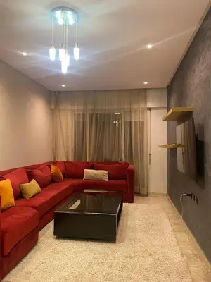a living room with a red couch and a coffee table at Marina Retreat in Oulad Akkou