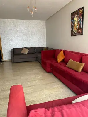 a living room with a red couch in a room at Marina Retreat in Oulad Akkou
