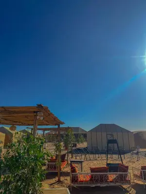 a group of chairs and a playground in the desert at Merzouga heritage camp in Merzouga