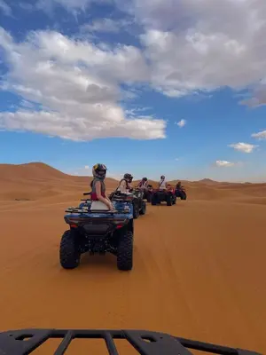 a group of people riding on atvs in the desert at Merzouga heritage camp in Merzouga