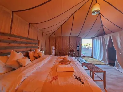 a bedroom with a large bed in a tent at Merzouga heritage camp in Merzouga
