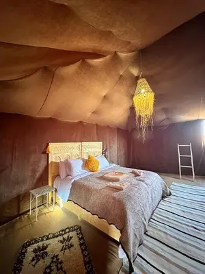 a bedroom with a large bed in a room with a ceiling at Merzouga heritage camp in Merzouga