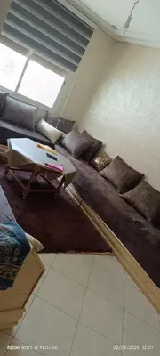 a living room with a couch and a table at appartement familial in Oulad Akkou