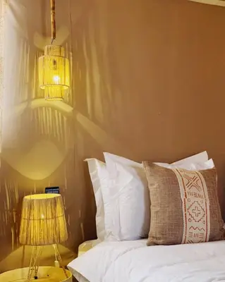 a bedroom with a bed with a bird cage on the wall at Merzouga white camp in Merzouga