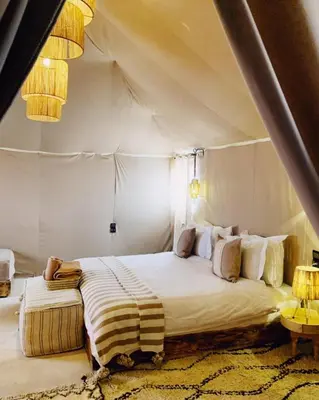 a bedroom with a large bed in a tent at Merzouga white camp in Merzouga