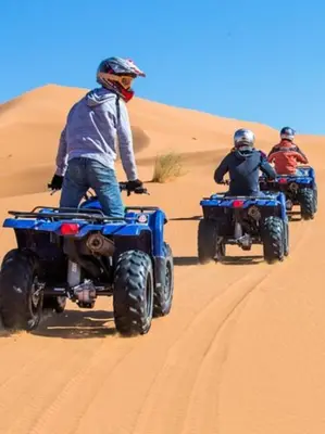 a group of people riding atvs in the desert at Merzouga white camp in Merzouga